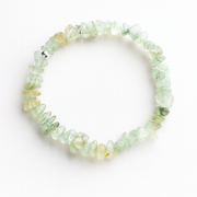 Prehnite chipstone crystal bracelet with one sterling silver bead on a white background, top-down product photo.